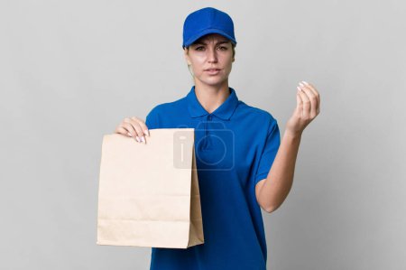 Photo for Caucasian blonde woman making capice or money gesture, telling you to pay. paper bag delivery concept - Royalty Free Image
