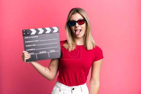 Foto de Young pretty woman with cheerful and rebellious attitude, joking and sticking tongue out. film, cinema and movie concept - Imagen libre de derechos