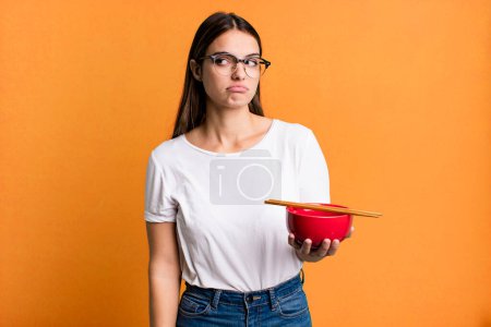 Photo for Young pretty woman feeling sad, upset or angry and looking to the side. japanese ramen noodles concept - Royalty Free Image
