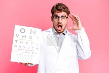 Photo for Young adult caucasian man screaming with hands up in the air. optical vision test concept - Royalty Free Image