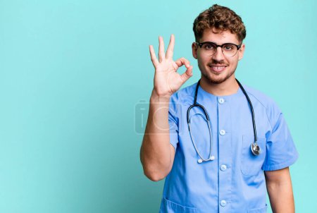 Téléchargez les photos : Young adult caucasian man feeling happy, showing approval with okay gesture. nurse concept - en image libre de droit