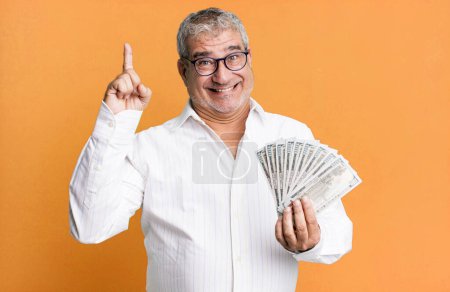 Photo for Middle age senior man feeling like a happy and excited genius after realizing an idea. dollar banknotes concept - Royalty Free Image