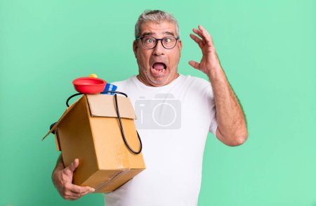 Photo for Middle age senior man screaming with hands up in the air. housekeeper repairman with a toolbox concept - Royalty Free Image