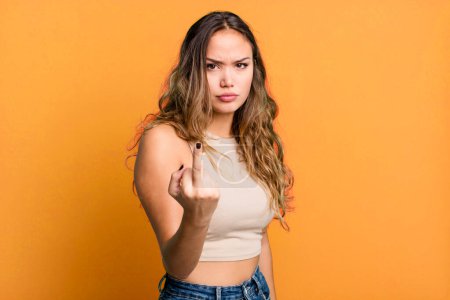 Foto de Joven bonita mujer sintiéndose enojado, molesto, rebelde y agresivo, volteando el dedo medio, luchando - Imagen libre de derechos