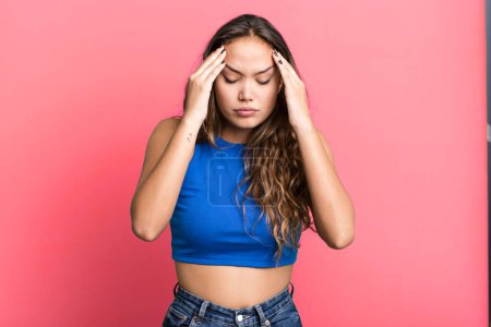 Photo for Young pretty woman looking stressed and frustrated, working under pressure with a headache and troubled with problems - Royalty Free Image