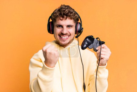 Foto de Young adult caucasian man with headset and a controller. gamer concept - Imagen libre de derechos