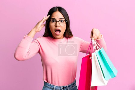 Foto de Hispanic pretty woman looking happy, astonished and surprised. shopping concept - Imagen libre de derechos