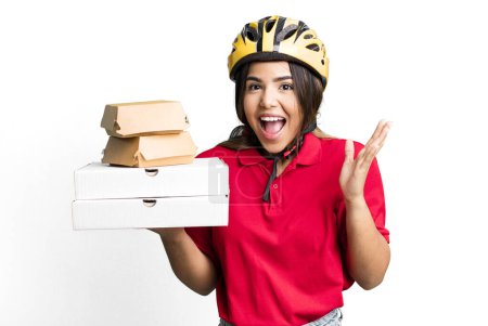 Photo for Hispanic pretty woman feeling happy and astonished at something unbelievable.  delivery woman and take away concept - Royalty Free Image