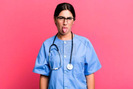 Foto de Ensación de disgusto e irritación y lengua fuera. concepto de enfermera - Imagen libre de derechos