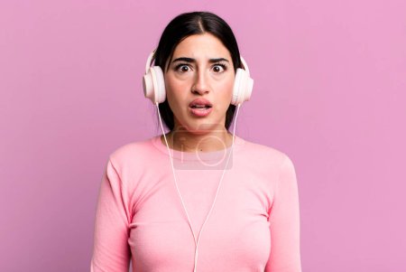 Foto de Looking very shocked or surprised. listening music with headphones - Imagen libre de derechos