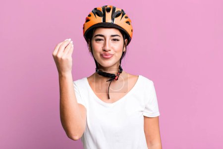 Photo for Making capice or money gesture, telling you to pay. bike helmet concept - Royalty Free Image