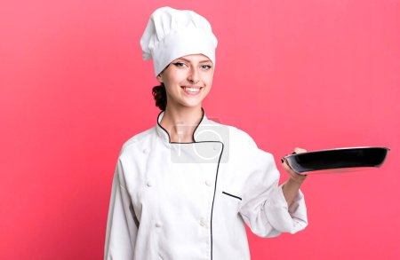 Photo for Caucasian pretty blonde woman. chef with a frying pan concept - Royalty Free Image