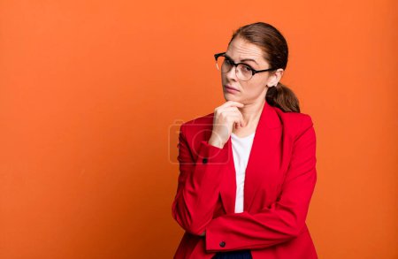 Téléchargez les photos : Young adult pretty businesswoman with red blazer and a copy space - en image libre de droit