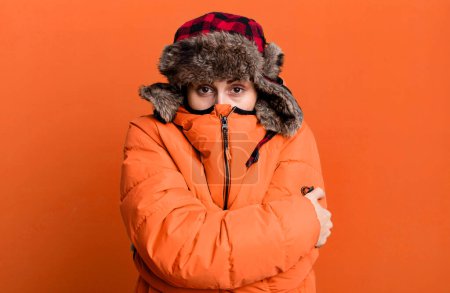 Photo for Young adult pretty woman wearing anorak and winter hat - Royalty Free Image