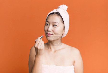 Téléchargez les photos : Jeune adulte jolie femme asiatique avec un rouge à lèvres. concept de beauté - en image libre de droit