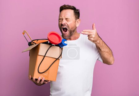 Photo for Middle age man looking unhappy and stressed, suicide gesture making gun sign. handyman with a toolbox - Royalty Free Image