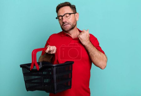 Foto de Hombre de mediana edad sentirse estresado, ansioso, cansado y frustrado. concepto de cesta de la compra vacía - Imagen libre de derechos