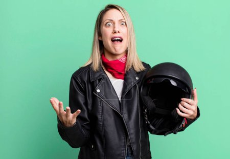 Foto de Pretty blonde woman looking desperate, frustrated and stressed. motorbike rider and helmet concept - Imagen libre de derechos