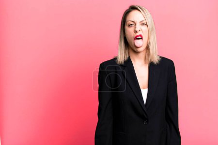 Foto de Bonita mujer rubia sintiéndose disgustada e irritada y la lengua hacia fuera. concepto de mujer de negocios - Imagen libre de derechos