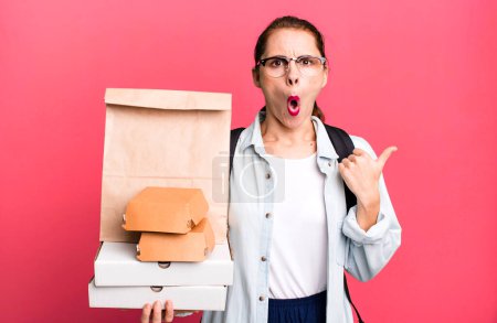 Foto de Una mujer bastante hispana que parece asombrada de incredulidad. entrega comida rápida take away concepto - Imagen libre de derechos