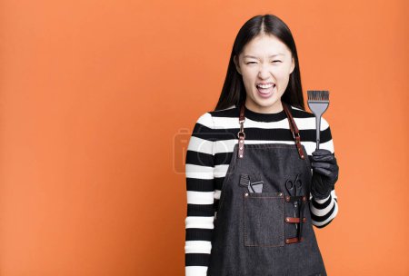 Foto de Bonita mujer asiática con actitud alegre y rebelde, bromeando y sacando la lengua. concepto de barbero - Imagen libre de derechos