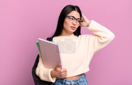 Photo for Hispanic pretty woman smiling happily and daydreaming or doubting. university student concept - Royalty Free Image