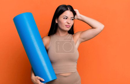 Photo for Hispanic pretty woman feeling puzzled and confused, scratching head yoga concept - Royalty Free Image