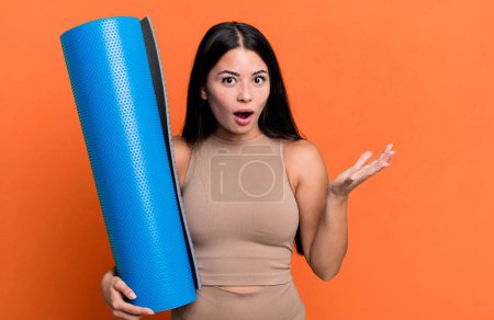 Foto de Hispanic pretty woman amazed, shocked and astonished with an unbelievable surprise yoga concept - Imagen libre de derechos