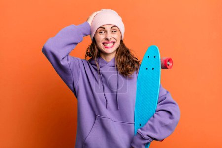 Foto de Hispanic pretty woman feeling stressed, anxious or scared, with hands on head. skate boarding concept - Imagen libre de derechos