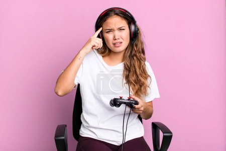 Photo for Hispanic pretty woman feeling confused and puzzled, showing you are insane. gamer concept - Royalty Free Image