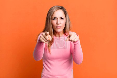 Photo for Blonde adult woman pointing forward at camera with both fingers and angry expression, telling you to do your duty - Royalty Free Image