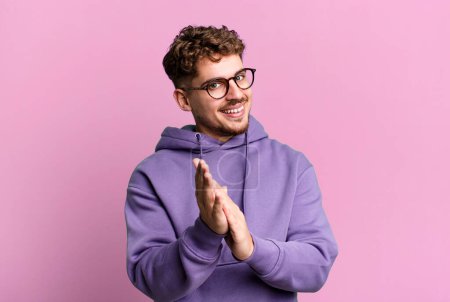 Photo for Young adult caucasian man feeling happy and successful, smiling and clapping hands, saying congratulations with an applause - Royalty Free Image