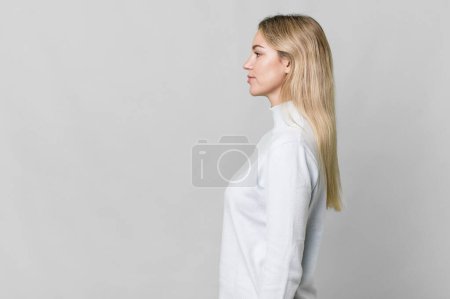 Téléchargez les photos : Caucasian blonde woman on profile view thinking, imagining or daydreaming. copy space concept - en image libre de droit