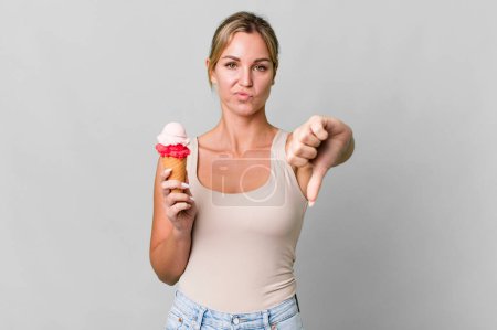 Photo for Caucasian blonde woman feeling cross,showing thumbs down. ice cream concept - Royalty Free Image