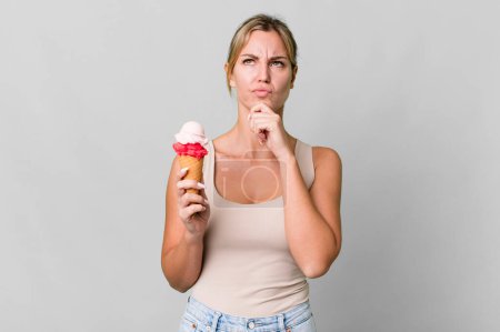 Photo for Caucasian blonde woman thinking, feeling doubtful and confused. ice cream concept - Royalty Free Image