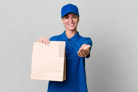 Photo for Caucasian blonde woman smiling happily with friendly and  offering and showing a concept. paper bag delivery concept - Royalty Free Image