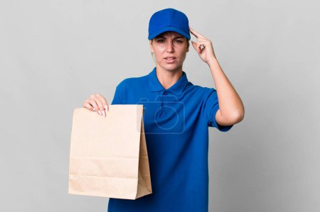 Photo for Caucasian blonde woman feeling confused and puzzled, showing you are insane. paper bag delivery concept - Royalty Free Image