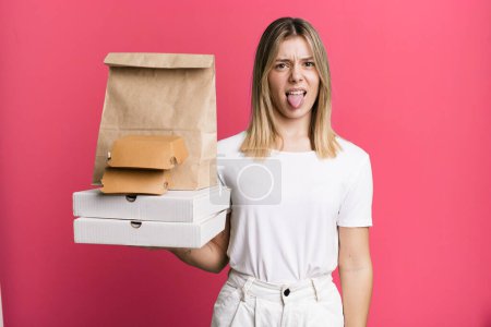 Photo for Young pretty woman feeling disgusted and irritated and tongue out. delivery and take away food concept - Royalty Free Image