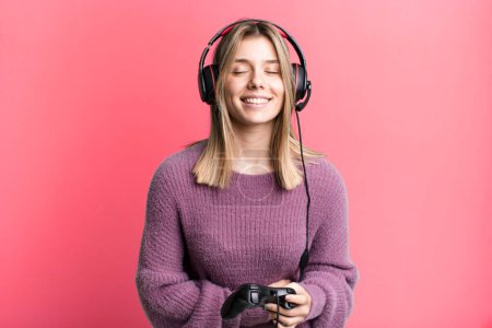 Photo for Young pretty woman laughing out loud at some hilarious joke. gamer with headset and controller - Royalty Free Image