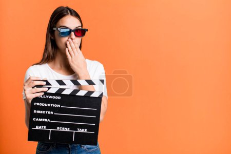 Photo for Young pretty woman covering mouth with hands with a shocked. cinema film or movie concept - Royalty Free Image