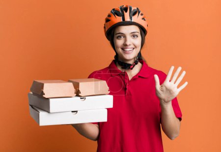 Photo for Young pretty woman smiling and looking friendly, showing number five. pizza delivery concept - Royalty Free Image