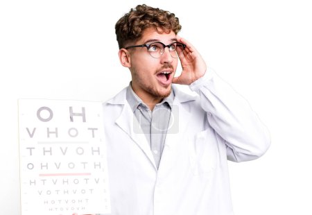 Foto de Young adult caucasian man feeling happy, excited and surprised. optical vision test concept - Imagen libre de derechos