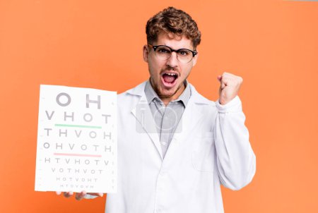 Photo for Young adult caucasian man shouting aggressively with an angry expression. optical vision test concept - Royalty Free Image