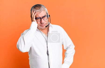 middle age senior man feeling bored, frustrated and sleepy after a tiresome. telemarketer or client attention agent concept
