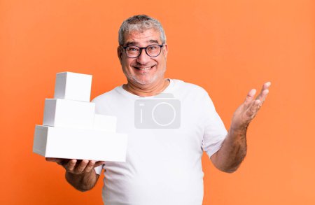 Téléchargez les photos : Homme âgé d'âge moyen se sentant heureux, surpris de réaliser une solution ou une idée. différents paquets boîtes vides - en image libre de droit
