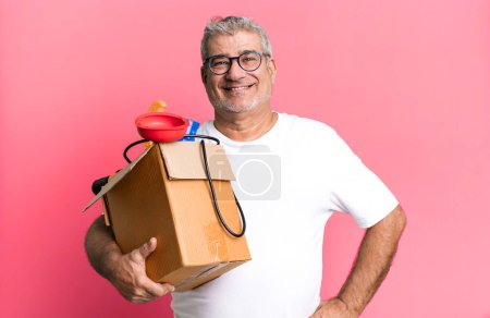 Foto de Hombre mayor de mediana edad sonriendo felizmente con una mano en la cadera y confiado. ama de llaves reparador con un concepto de caja de herramientas - Imagen libre de derechos
