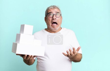 Photo for Middle age senior man looking desperate, frustrated and stressed. different packages blank boxes - Royalty Free Image