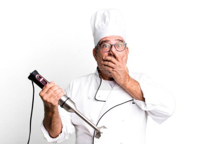 Téléchargez les photos : Homme âgé d'âge moyen couvrant la bouche avec les mains avec un choc. chef de restaurant avec un concept d'outil - en image libre de droit