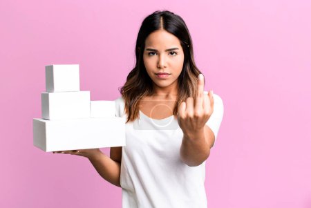 Foto de Hispanic pretty woman feeling angry, annoyed, rebellious and aggressive with blank packages boxes - Imagen libre de derechos