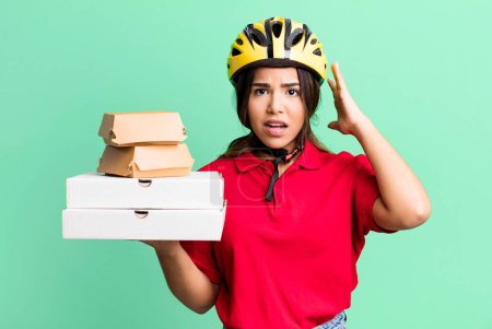 Photo for Hispanic pretty woman feeling stressed, anxious or scared, with hands on head.  delivery woman and take away concept - Royalty Free Image